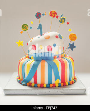 Funny birthday cake with number one on top, sweet colorful decoration. Stock Photo