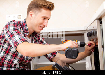 repairman set the oven in the kitchen Stock Photo
