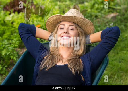 Pretty blonde lying in wheelbarrow Stock Photo
