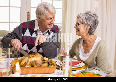 Grandfather carving roast turkey at christmas dinner Stock Photo