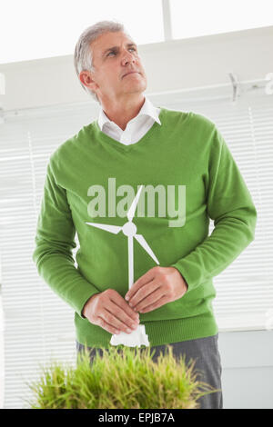 Casual businessman holding model wind turbine Stock Photo