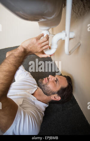 Plumber fixing the sink in a bathroom Stock Photo