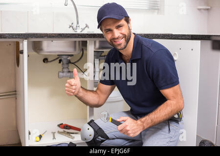 Plumber fixing under the sink Stock Photo