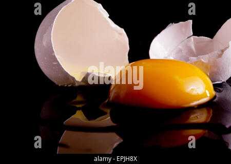 Cracked Egg with Shell Isolated on Black Stock Photo