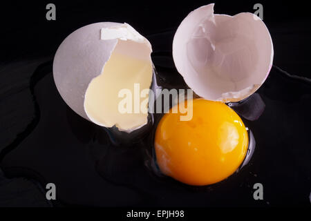 Cracked Egg with Shell Isolated on Black Stock Photo