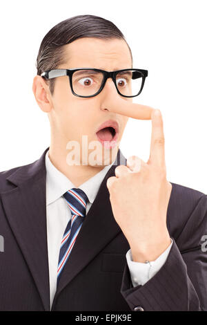 Vertical shot of a young displeased businessman looking at his long nose and trying to put it back with his finger Stock Photo