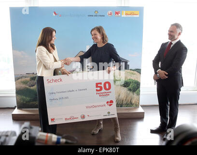 Hamburg, Germany. 19th May, 2015. Mary, Crown Princess of Denmark, hands a 'cheque' for 50 Denmark vacations to Heike Bullmann, general manager of the organisation 'Bruecke' (lit. Bridge) Rendsburg-Eckernfoerde at Hotel Scandic in Hamburg, Germany, 19 May 2015. Carlo Lassen, president of the association of Danish vacation home suppliers, is pictured to their right. Frederik, Crown Prince of Denmark, and his wife Mary are on a working visit to Germany entitled 'Danish Living' until 21 May 2015. Credit:  dpa picture alliance/Alamy Live News Stock Photo