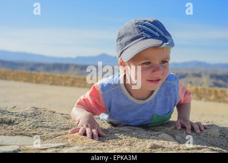 Little boy laying down on the rock Stock Photo