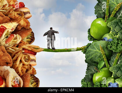 Diet change healthy lifestyle concept and having the courage to accept the challenge of losing weight and fighting obesity and diabetes as an overweight person walking on a highwire asparagus from fatty food towards vegetables and fruit. Stock Photo