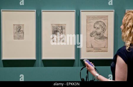 A woman holds a specially made audio guide in her hand as she looks at the copperplate engravings 'Martin Luther als Augustinermoench' (L-R, lit. Martin Luther as Augustinian monk), 'Martin Luther als Moench' (lit. Martin Luther as Monk, both 1520) and 'Martin Luther as Junker Joerg' (1522) by Lucas Cranach the Elder prior to the opening of the exhibition 'Between Venus and Luther: Cranach's Media of Temptation' at the Germanisches Nationalmuseum (Germanic National Museum) in Nuremberg, Germany, 18 May 2015. The museum puts the works of Lucas Cranach the Elder (1472 - 1553) into focus on occas Stock Photo