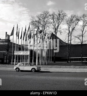 1960s, historical, an Austin Morris car is parked outside The Commonwealth Institute, Kensington High Street. London,  famous for its distinctive roof,  the shape of which reflects the architects' desire to create a 'tent in the park'. Stock Photo