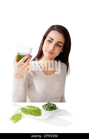 Beautiful smiling girl holding green juice in hand. Spirulina, chlorella and wheatgrass. Healthy lifestyle, detox. Stock Photo
