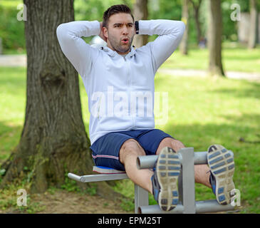 Man make abs exercise in a park Stock Photo