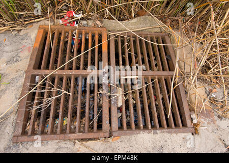 Metal storm drain with trash littered inside Stock Photo