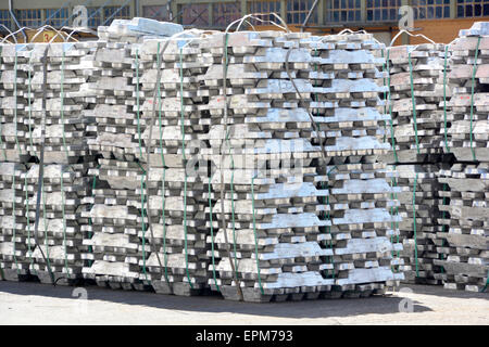 Dockside piles of aluminium ingots wired together to aid bulk handling by crane & fork lift truck wait onward transportation Port of Koper Slovenia Stock Photo