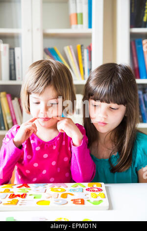 Portrait of two sisters with wooden alphabet puzzle Stock Photo