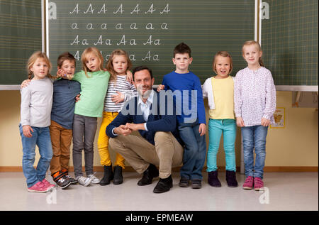 Happy teacher with pupils in classroom Stock Photo - Alamy