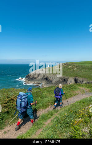 A couple of mature hikers along the Pembrokeshire coastal path near Porthgain. Pembrokeshire. Wales. Cymru. UK Stock Photo