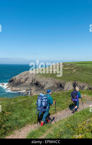 A couple of mature hikers along the Pembrokeshire coastal path near Porthgain. Pembrokeshire. Wales. Cymru. UK Stock Photo