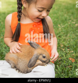 A child with a brown rabbit on her lap. Stock Photo