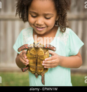 A child holding a tortoise. Stock Photo