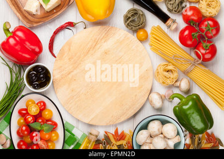 Italian food cooking ingredients. Pasta, vegetables, spices. Top view with cutting board for copy space Stock Photo