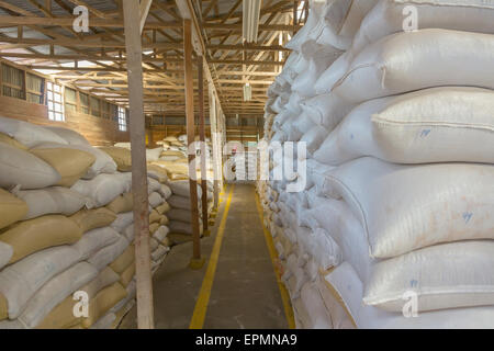 Stack of bags with coffee beans at warehouse Stock Photo