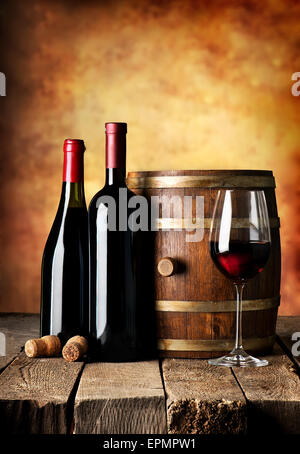 Bottles and cask of wine on a wooden table Stock Photo