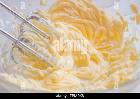Whisking butter, in a bowl full of butter and egg yolks Stock Photo
