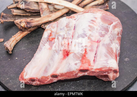 Raw pork ribs, in front of a pile of bones Stock Photo