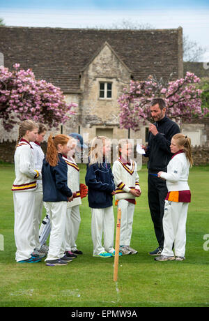 Junior girls prepare for a cricket match with their coach in Wiltshire, England Stock Photo