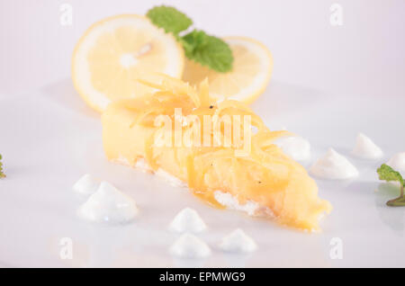 Lemon creme cake and lemons, on white background Stock Photo