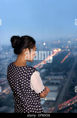Young woman watching the view from skyscraper Stock Photo