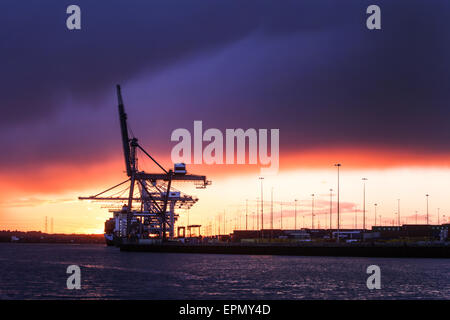 Storm clouds gather over the container port in Southampton Docks as the sun sets Stock Photo