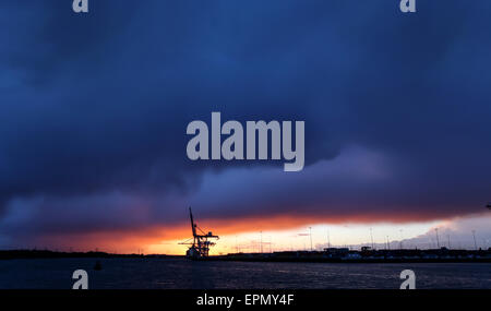 Storm clouds gather over the container port in Southampton Docks as the sun sets Stock Photo