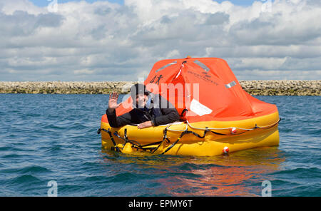 Portland Harbour, Dorset, UK. 18th May, 2015. A former soldier is hoping his seven days and nights in a life raft will be a lifeline to Great Ormond Street Hospital too in his unique fundraising effort.  His tiny life raft was towed out to a bouy and secured there in Portland Harbour today (mon) until next Monday as he started his survival period with just the items that one would have on such an emergency craft. Wayne Ingram, from Portland, has raised thousands of pounds for children around the world but now wants to do his bit for children in the UK. Credit:  Dorset Media Service/Alamy Live  Stock Photo