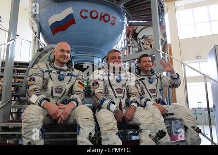 International Space Station Expedition 40 crew members ESA astronaut Alexander Gerst (left), Soyuz commander Max Suraev and NASA astronaut Reid Wiseman (right) pose in front of a Soyuz simulator at the Gagarin Cosmonaut Training Center May 6, 2015 in Star City, Russia. Stock Photo