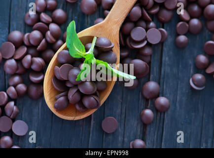 sweet chocolate in wooden spoon and on a table Stock Photo