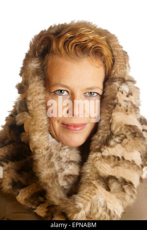 Portrait of a caucasian blond woman with blue eyes wearing an ecologic fur hood over a white background. Stock Photo