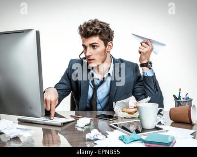 Office worker with paper plane in his hand typing on a computer keyboard Stock Photo