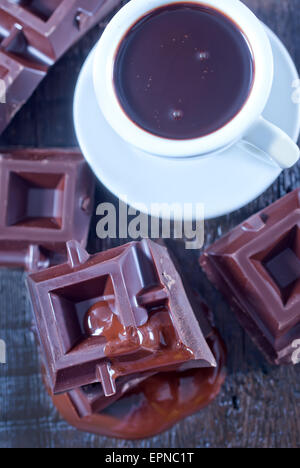 chocolate in cup and on the wooden table Stock Photo