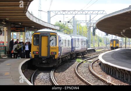 Two diesel multiple unit trains at and approaching Carnforth railway station, both Northern livery going to Lancaster and Leeds Stock Photo