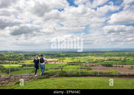 A young couple enjoying the view from Beeston castle overlooking the Cheshire plain on a spring day. Stock Photo