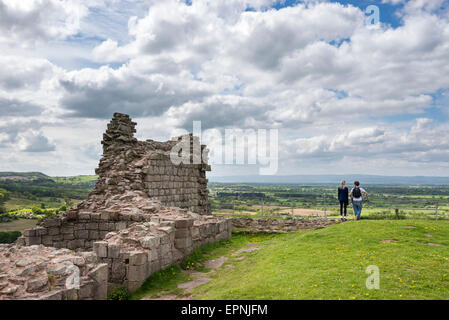 A young couple stand at the edge of the hilltop castle at Beeston looking over the magnificent view of the Cheshire plain. Stock Photo