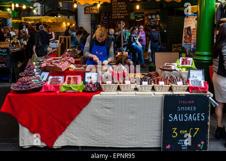 Two Women Sell Smoked Sausages From A Stall In Borough Market, London Bridge Area, London, England Stock Photo