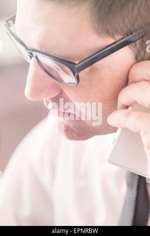Businessman talking on cell phone in office. Stock Photo