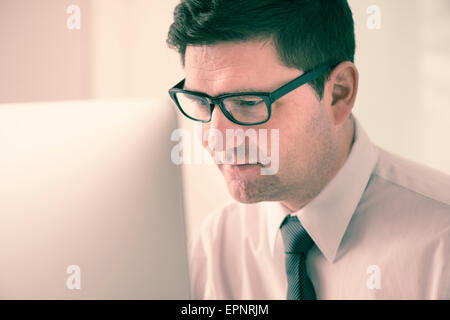 Businessman sitting by desk, working with computer in office. Stock Photo