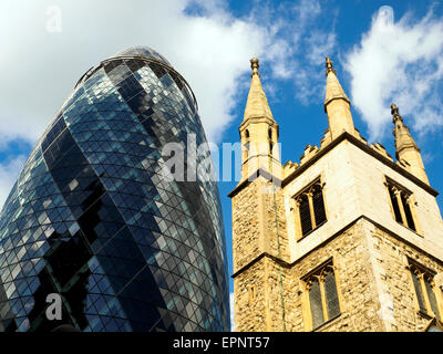 30 St Mary Axe (widely known informally as The Gherkin and previously as the Swiss Re Building) and  St Andrew Undershaft church - London, England Stock Photo