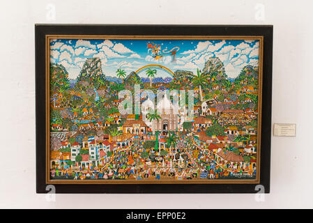 Fiestas Patronales De Boaco Folk Art Painting Granada Nicaragua | GRANADA, Nicaragua — Mario Marin's 1981 painting "Fiestas Patronales de Boaco" hangs in the Centro Cultural Convento San Francisco, showing Santiago Apostol on horseback above a crowded plaza and twin-towered church. The densely populated folk-art composition documents a Nicaraguan patron-saint festival, a tradition blending Catholic ritual with communal celebration. Stock Photo