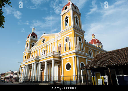 GRANADA, Nicaragua — The Cathedral of Granada, with its distinctive yellow and white exterior, dominates the skyline at Parque Central. There has been a church on this spot since about 1525, but it was destroyed and rebuilt several times in the following centuries as the city of Granada was attacked by pirates and others. Construction on the current version began in 1888 but was not fully completed until 1972. With its distinctive yellow with white trim exterior, it stands over Parque Central in the heart of Granada, Nicaragua. Stock Photo